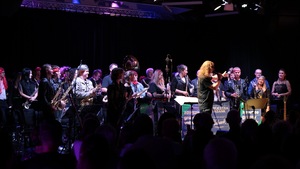 Artyści Chóru Męskiego stojący na scenie na sali widowiskowej podczas koncertu