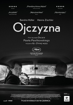 Plakat filmu „Ojczyzna” Pawła Pawlikowskiego w czerni i bieli. Przy stole siedzą kobieta i mężczyzna, oboje patrzą poważnie przed siebie. Minimalistyczna kompozycja podkreśla melancholijny i artystyczny charakter filmu.