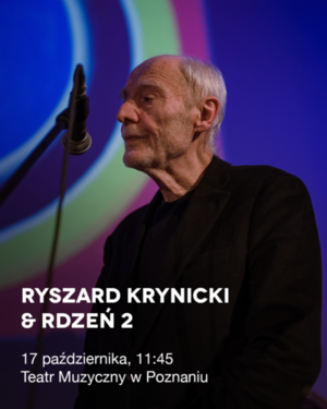 Starszy mężczyzna z profilu przed mikrofonem - w tle kolorowa projekcja.