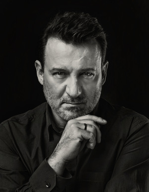 Czarno-biały portret zamyślonego mężczyzny.