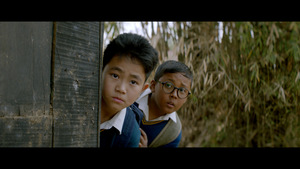 Kadr z filmu. Dwoje chłopców przygląda się czemuś.