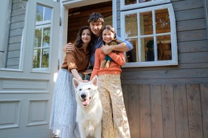 Kadr z filmu animowanego. Dwoje dorosłych, chłopiec i pies przytulają się.