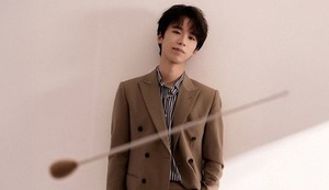 stojący mężczyzna, a przed nim batuta