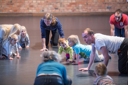 Dzieci i dorośli poruszają się na rękach i kolanach po podłodze