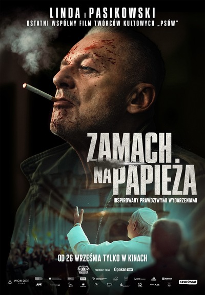 na ciemnym tle Bogusław Linda z papierosem