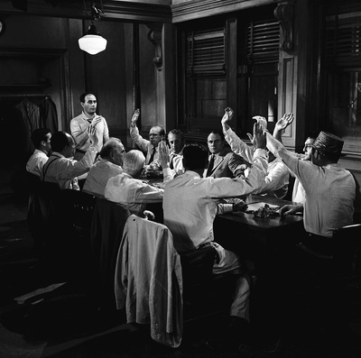 Kadr z filmu. Grupa mężczyzn siedzi przy stole.