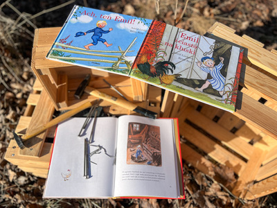 Otwarte książki dla dzieci leżą na drewnianych skrzynkach na dworze