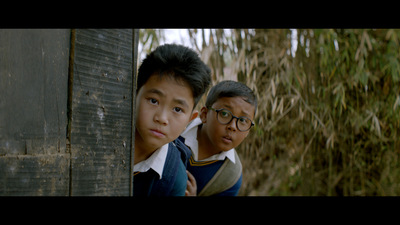 Kadr z filmu. Dwoje chłopców wygląda zza rogu.