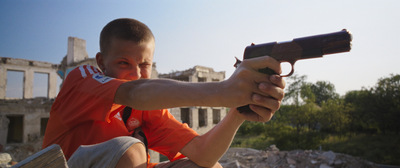 Kadr z filmu. Chłopak trzyma broń.