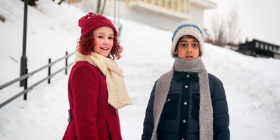 Kadr z filmu. Chłopiec i dziewczynka stoją na śniegu.