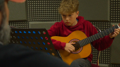 chłopiec gra na gitarze