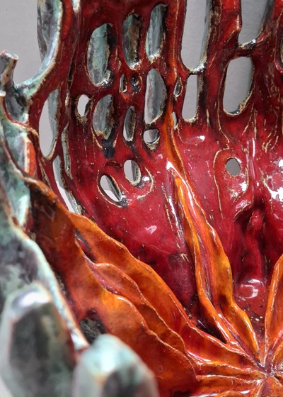 To jest praca ceramiczna, jej fragment, sfotografowany w dużym przybliżeniu. Ceramika w kolorach czerwieni i pomarańczu inspirowana rafą koralową.